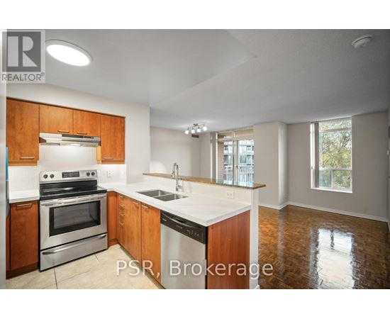 A kitchen with wooden cabinets and a stainless steel oven.
