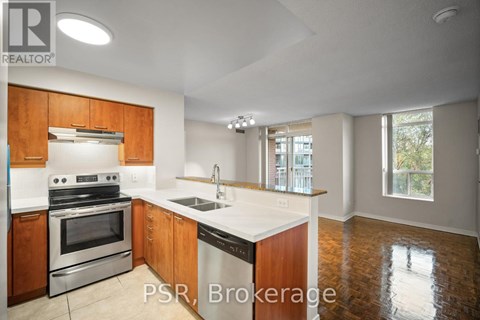 A kitchen with wooden cabinets and a stainless steel oven.