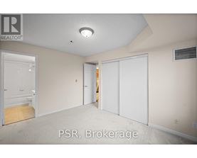 A room with a carpet floor and a ceiling light.