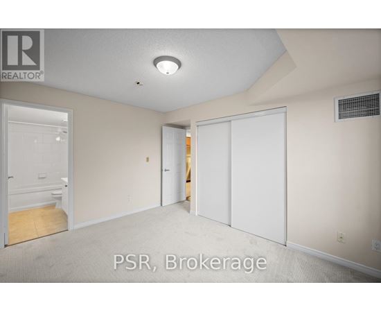 A room with a carpet floor and a ceiling light.