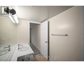 A bathroom with a sink, mirror, and towel bar.