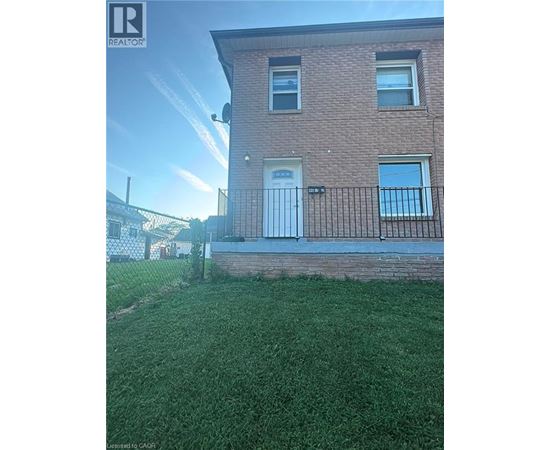 A brick house with a white door and windows.