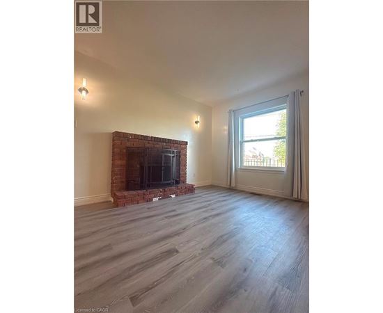 A living room with a fireplace and a large window.