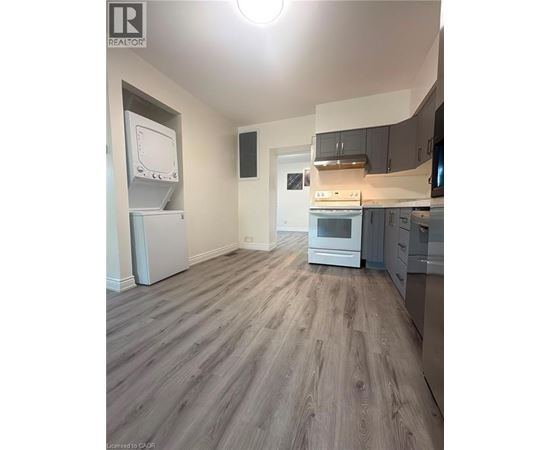 A kitchen with a refrigerator, oven, and microwave.