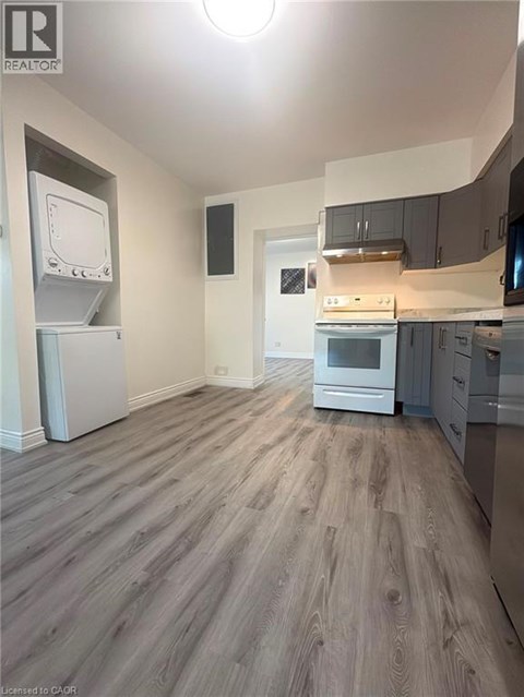 A kitchen with a refrigerator, oven, and microwave.