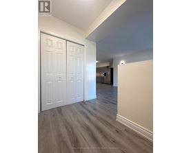 A room with a white door and a wooden floor.