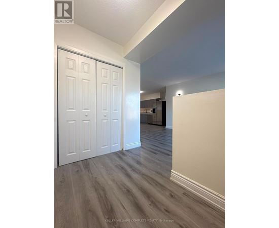 A room with a white door and a wooden floor.