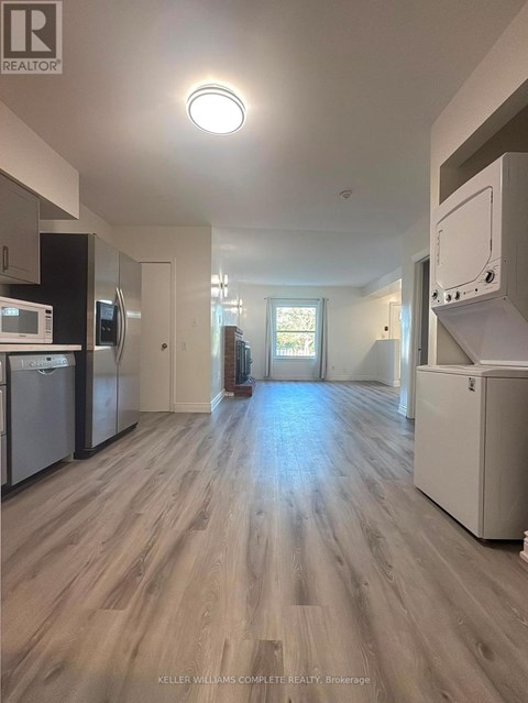 A kitchen with a refrigerator, dishwasher, and oven.