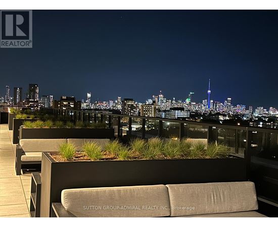 A rooftop patio with a view of the city skyline at night.