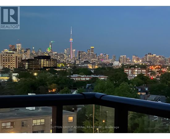 A cityscape at dusk with the CN Tower visible in the distance.