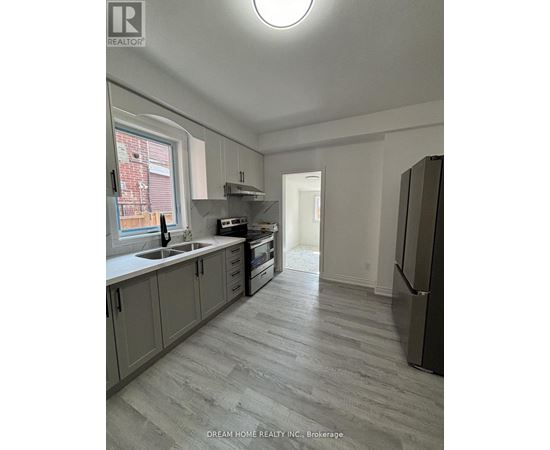 A kitchen with a refrigerator on the right side.