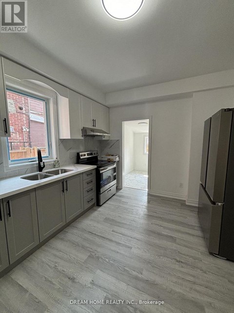 A kitchen with a refrigerator on the right side.