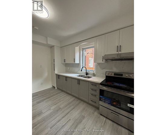 A kitchen with a stove top oven and a sink.