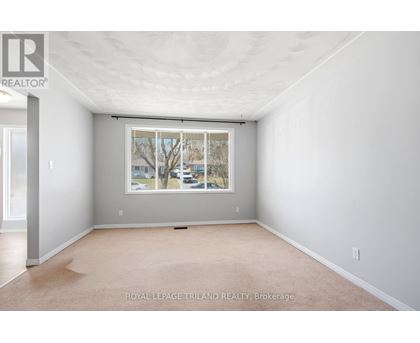 A white room with a window and a carpet on the floor.