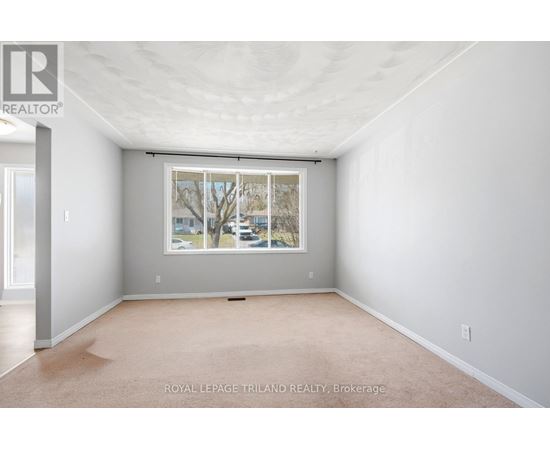 A white room with a window and a carpet on the floor.