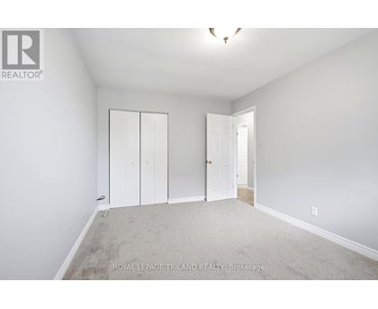 A white bedroom with a carpet floor and a white door.