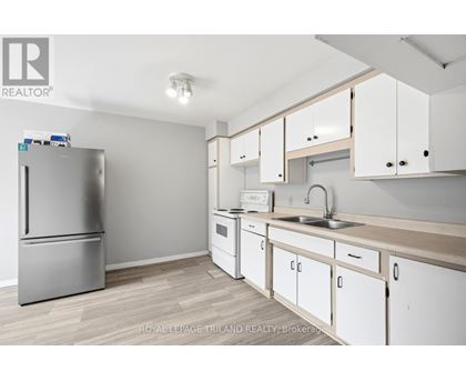 A kitchen with white cabinets and a stainless steel refrigerator.