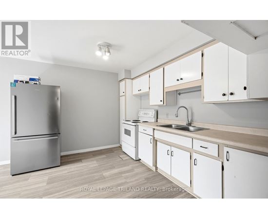 A kitchen with white cabinets and a stainless steel refrigerator.