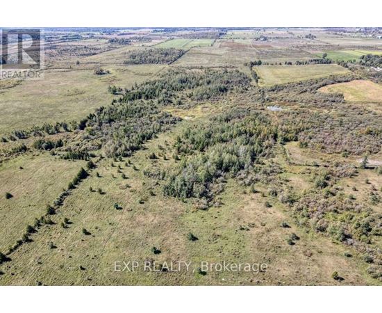 An aerial view of a landscape with a mix of greenery and open fields.