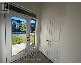 A white door with a glass window is open, showing a residential area outside.