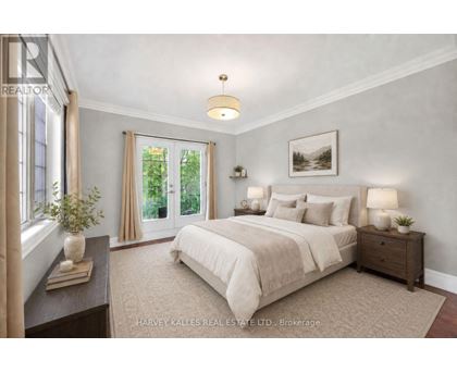 A bedroom with a large bed, a nightstand with a lamp, and a window with curtains.