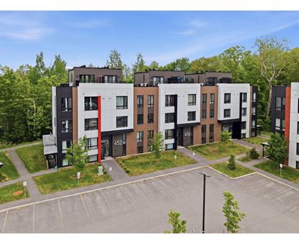 A modern apartment building with cars parked in front.