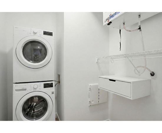 A white washing machine and dryer in a small laundry room.