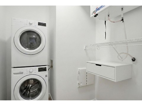 A white washing machine and dryer in a small laundry room.