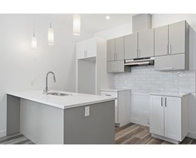 A kitchen with white cabinets and a white countertop.