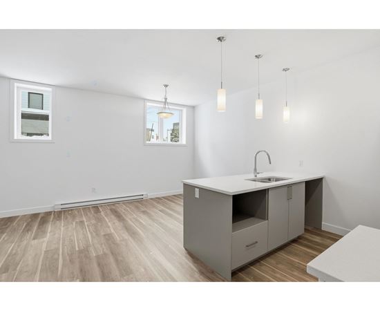 A kitchen with a sink, cabinets, and a window.
