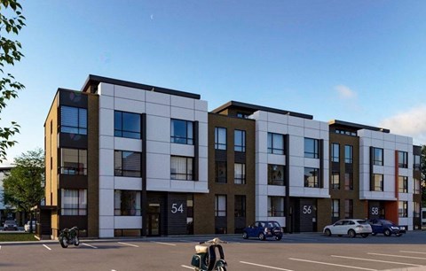 A modern apartment building with cars parked in front.