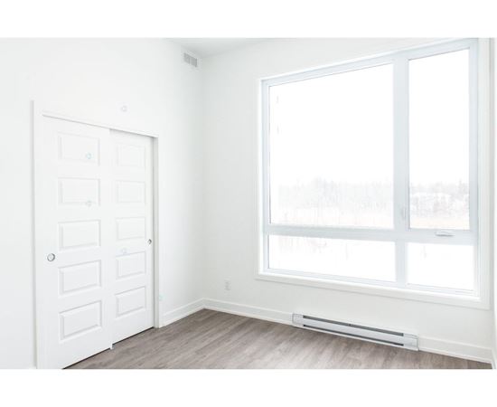 A white door and window in a room with a grey floor.