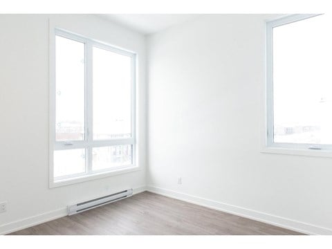 A room with a window and a wall-mounted air conditioner.
