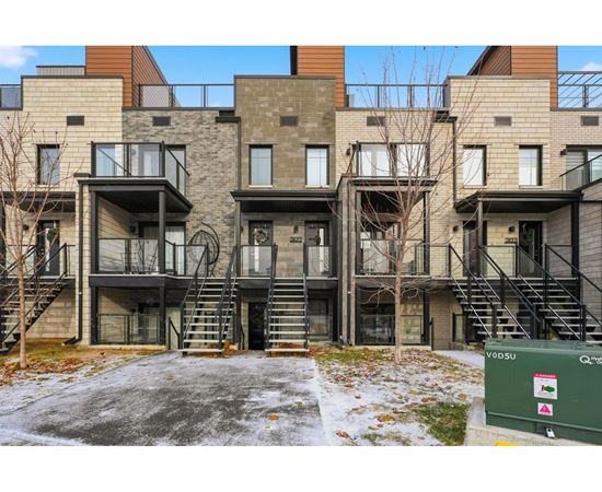 Apartment complex with a green dumpster in front.