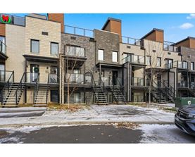 A row of modern townhouses with a car parked in front.