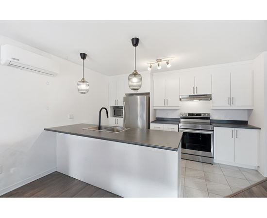 A modern kitchen with a stainless steel island and white cabinets.
