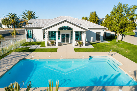 A house with a pool in front of it.