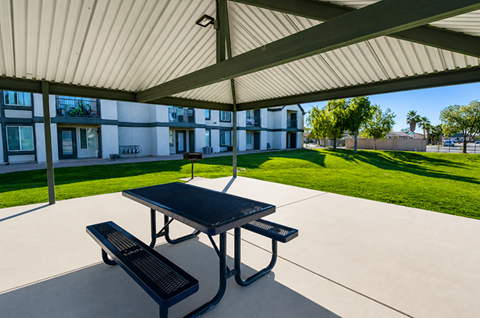 A black picnic table and bench under a white canopy.