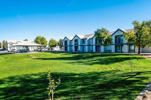 A row of houses with green lawns in front.