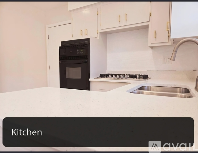A kitchen with a black oven and white cabinets.