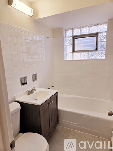 A bathroom with a toilet, sink, and bathtub.