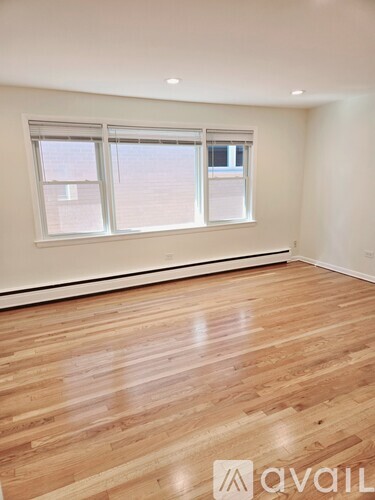 A room with wooden flooring and a window.