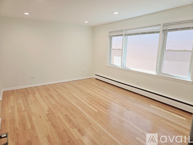 A room with wooden flooring and a window.