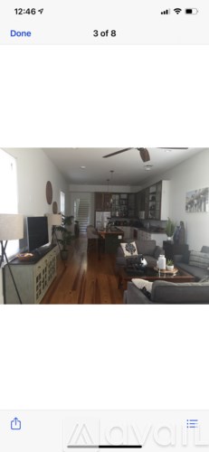 A living room with a grey couch and a wooden floor.