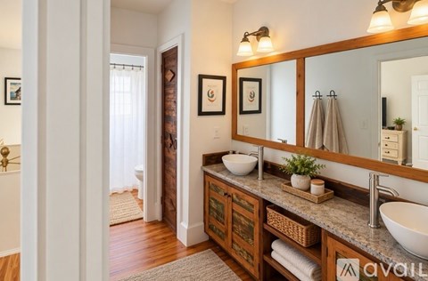A bathroom with a sink, mirror, and a towel on the floor.