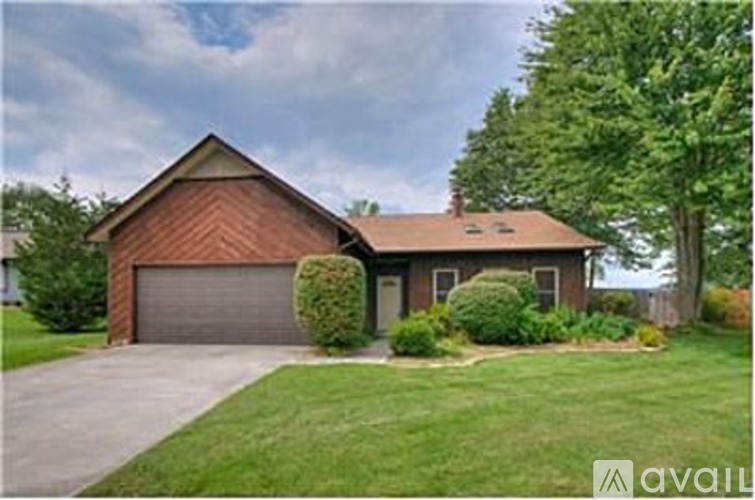 A house with a brown roof and a grey garage door.