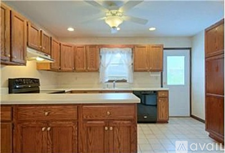 A kitchen with wooden cabinets and a white countertop.