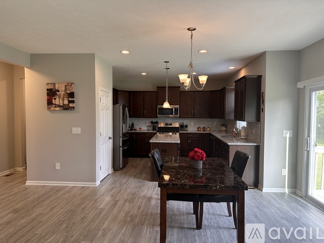 A kitchen with a table and chairs in the middle of the room.