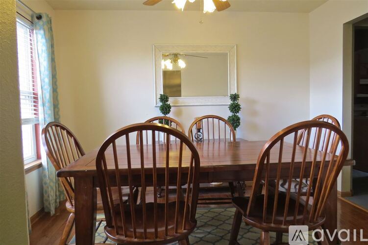 A dining room with a wooden table and chairs.