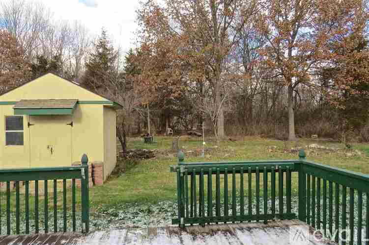 A yellow building with a green fence in front of it.